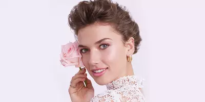 Mujer con el cabello en updo usando maquillaje natural bastante suave para el día de la boda.