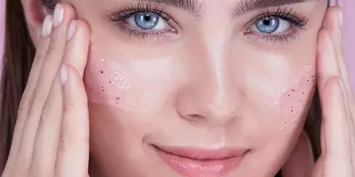 Mujer practicando cómo exfoliar el rostro con el exfoliante de azúcar y rosas Lancôme Rose