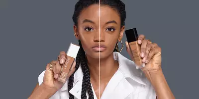 Modelo con envases de la base mate Teint Idole y la base Teint Idôle Care & Glow.