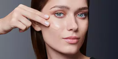 Mujer aplicando base sobre la piel grasa con las puntas de los dedos