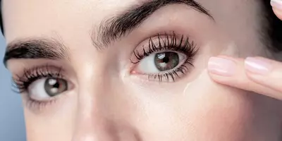 Lily Collins aplicando crema para ojos Lancôme en el área del contorno de los ojos