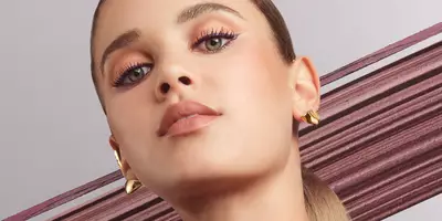 Mujer caucásica con el estilo de maquillaje de ojos de Lancôme en tono borgoña