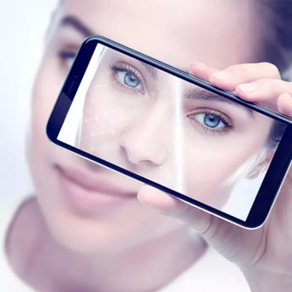 Mujer tomándose un selfie con teléfono inteligente para usar e-youth finder y las herramientas virtuales de servicios de belleza.